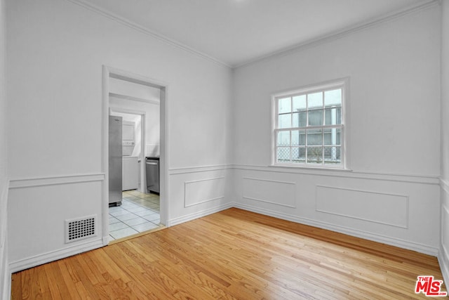 unfurnished room with crown molding and light hardwood / wood-style floors