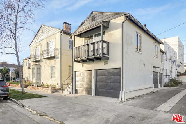 view of front of property featuring a garage and a balcony