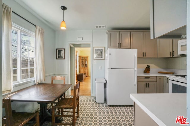 kitchen featuring decorative light fixtures, white appliances, and gray cabinets