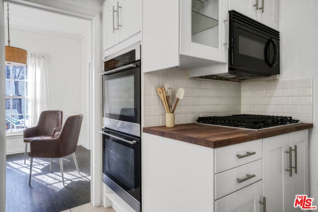 kitchen with double oven, wooden counters, white cabinets, gas cooktop, and decorative backsplash