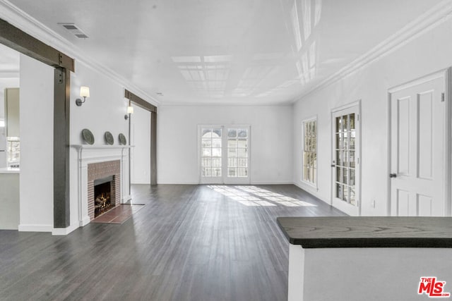 unfurnished living room featuring dark hardwood / wood-style floors, ornamental molding, french doors, and a fireplace