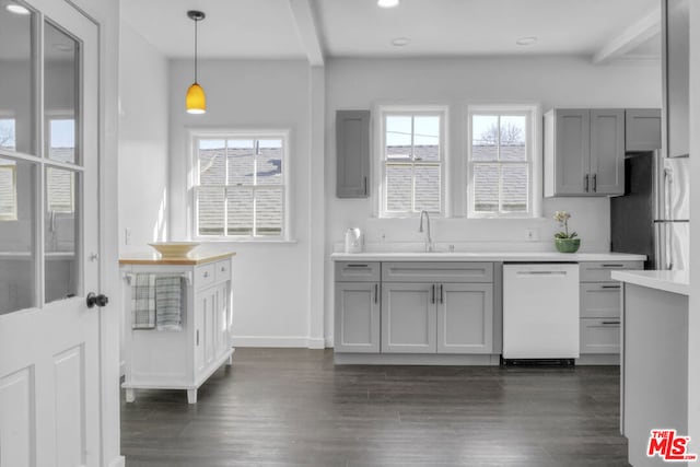 kitchen with white dishwasher, sink, gray cabinets, and beam ceiling