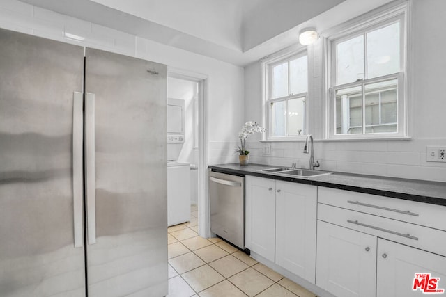 kitchen with white cabinetry, light tile patterned floors, sink, backsplash, and stainless steel appliances