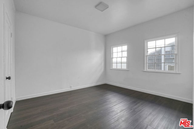 unfurnished room with dark hardwood / wood-style flooring