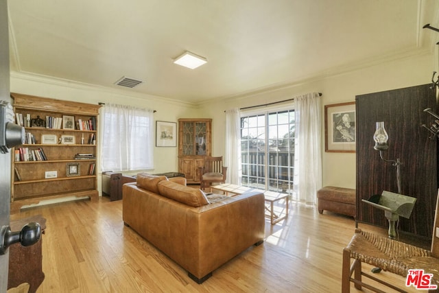 living room with light hardwood / wood-style flooring and crown molding