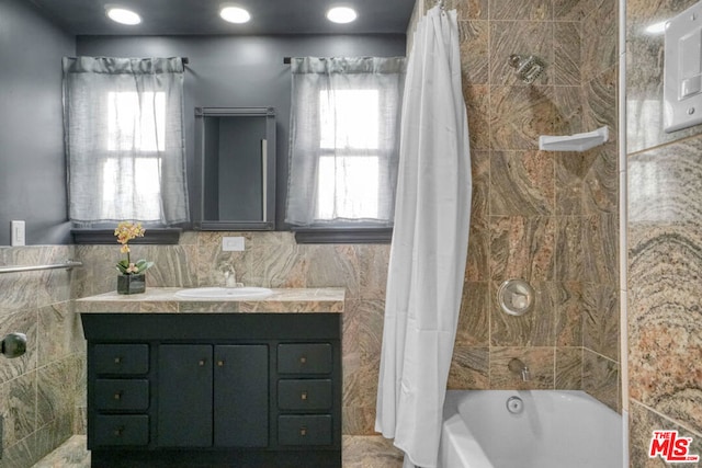 bathroom featuring plenty of natural light, vanity, and shower / bath combination with curtain