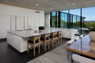 kitchen with dark hardwood / wood-style flooring, white cabinetry, expansive windows, and a kitchen island with sink