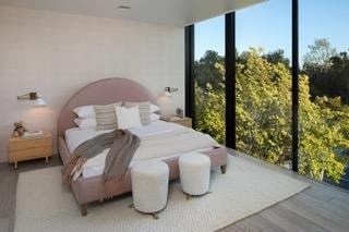 bedroom featuring a wall of windows and hardwood / wood-style floors