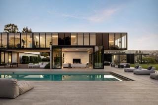 rear view of property with a patio area and a fireplace