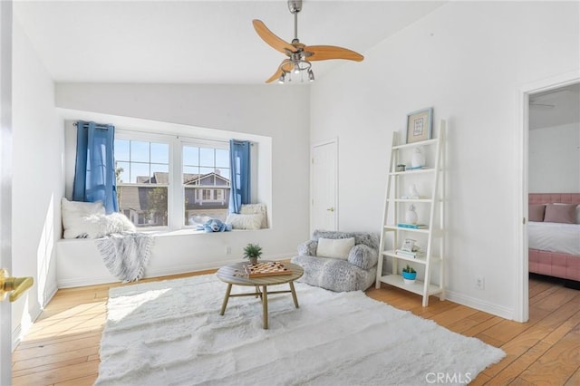 living area featuring vaulted ceiling, ceiling fan, and light hardwood / wood-style floors