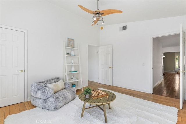 sitting room featuring ceiling fan, lofted ceiling, and wood-type flooring