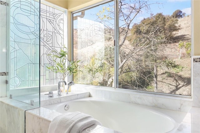 bathroom featuring a relaxing tiled tub