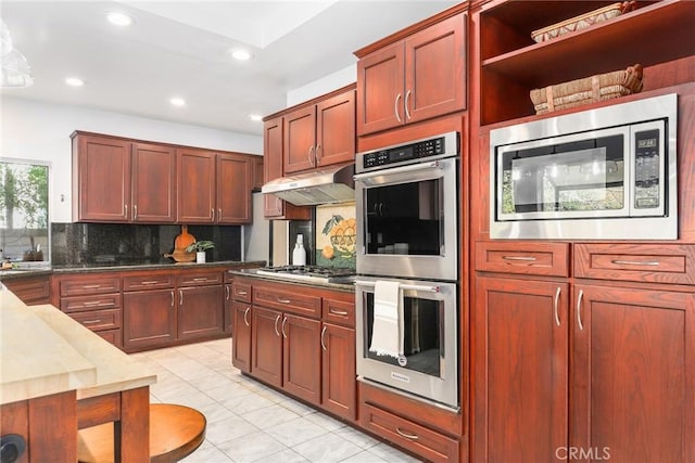 kitchen featuring tasteful backsplash, light tile patterned flooring, and appliances with stainless steel finishes