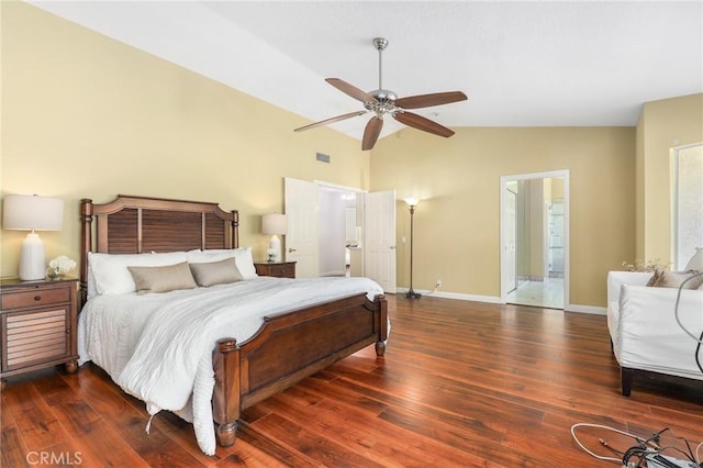 bedroom featuring lofted ceiling, ensuite bath, dark wood-type flooring, and ceiling fan