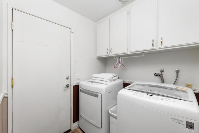 clothes washing area featuring cabinet space and washing machine and dryer