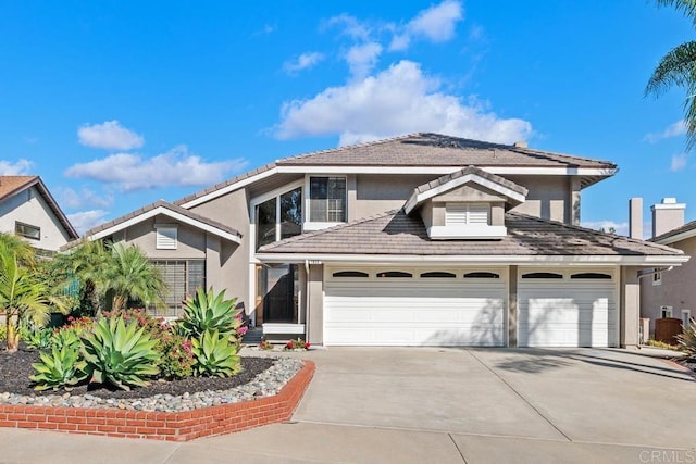 view of front of home featuring driveway, a tile roof, and stucco siding