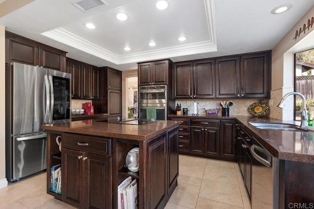 kitchen with dark countertops, a kitchen island, and a tray ceiling