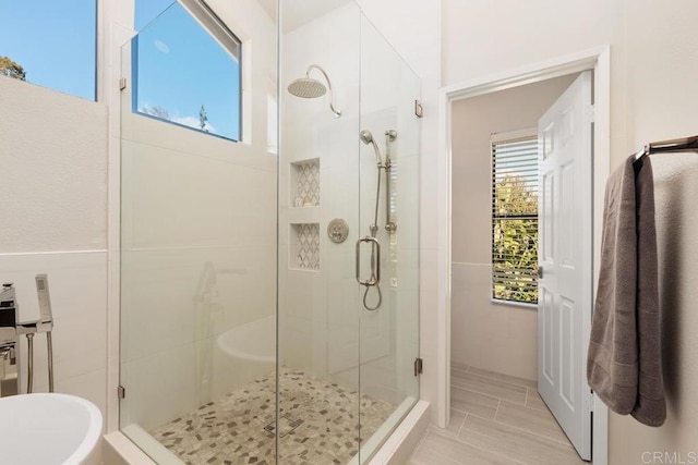 bathroom with a freestanding tub and a shower stall