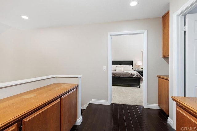 hall with baseboards, dark wood-style flooring, and recessed lighting