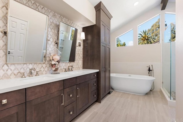 full bathroom with a freestanding bath, double vanity, and a sink