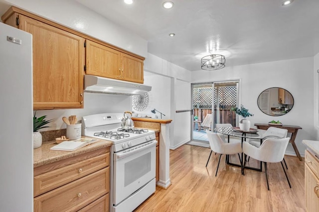 kitchen with white appliances, light brown cabinets, a chandelier, and light wood-type flooring