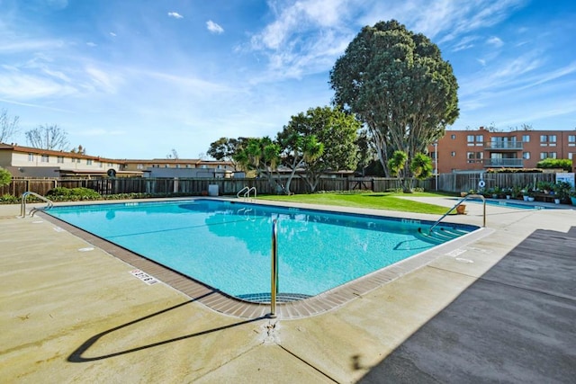 view of pool featuring a lawn