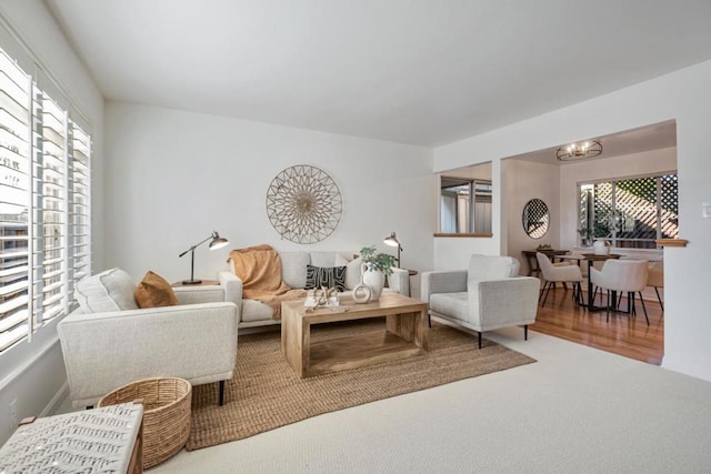 carpeted living room featuring a chandelier