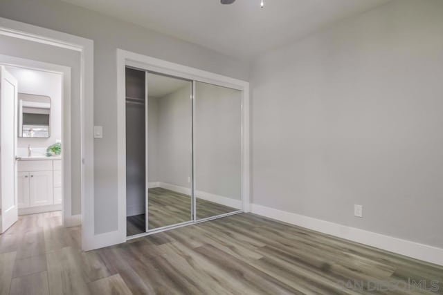 unfurnished bedroom featuring wood-type flooring and a closet