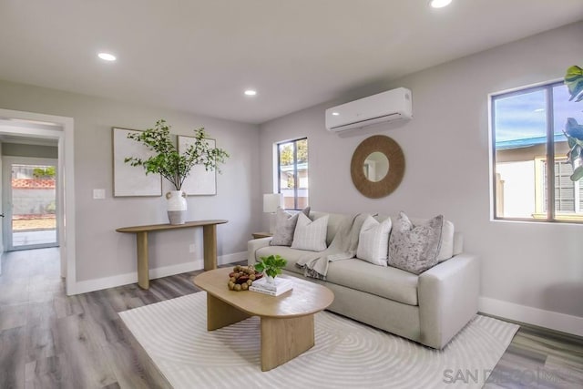 living room featuring light wood-type flooring and a wall mounted air conditioner