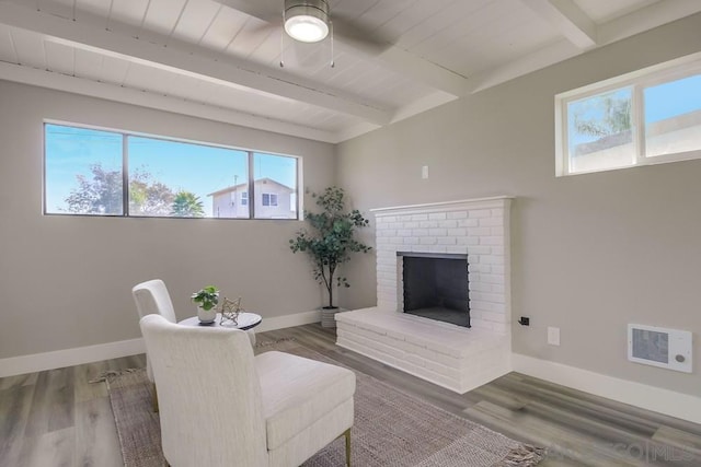 living room featuring a brick fireplace, hardwood / wood-style floors, and beam ceiling