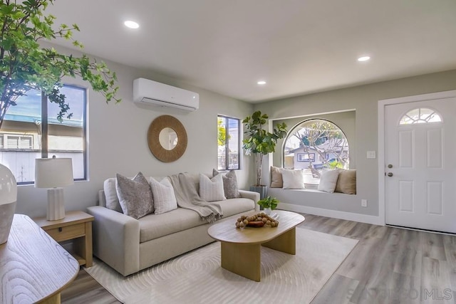 living room featuring an AC wall unit and light hardwood / wood-style flooring