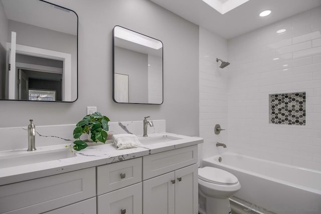 full bathroom featuring tiled shower / bath combo, toilet, and vanity