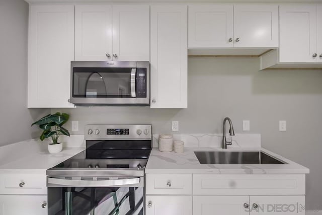 kitchen with sink, stainless steel appliances, and white cabinets