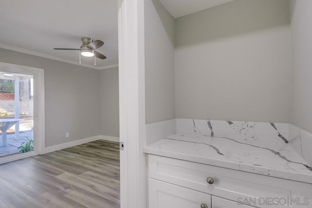 interior space featuring light wood-type flooring, ceiling fan, and ornamental molding