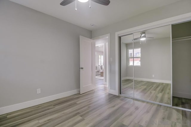 unfurnished bedroom with a closet, ceiling fan, and light hardwood / wood-style flooring