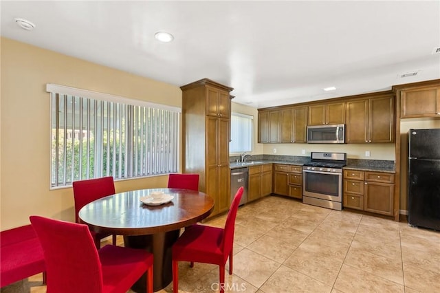 kitchen with sink, light tile patterned floors, and appliances with stainless steel finishes