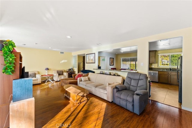 living room with sink and dark wood-type flooring