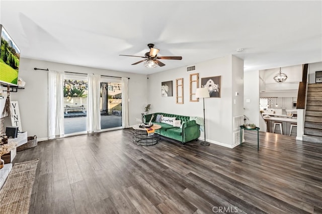 living room with ceiling fan and dark hardwood / wood-style flooring