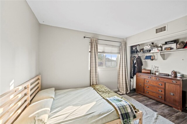 bedroom featuring dark wood-type flooring and a closet