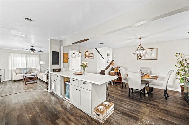 kitchen featuring a kitchen bar, white cabinetry, dark hardwood / wood-style floors, and hanging light fixtures