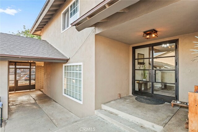 view of exterior entry featuring french doors and a patio