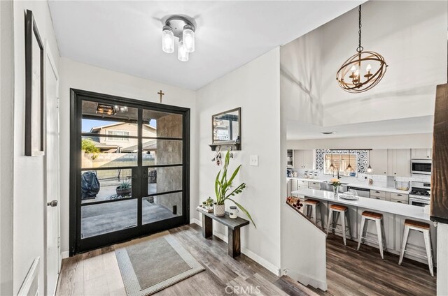 foyer with hardwood / wood-style floors and an inviting chandelier