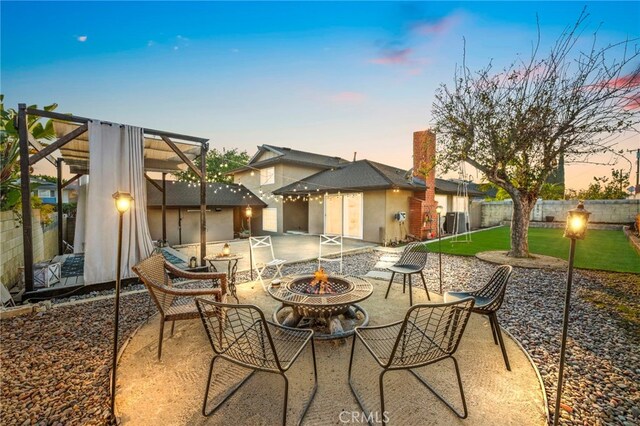 patio terrace at dusk featuring a fire pit