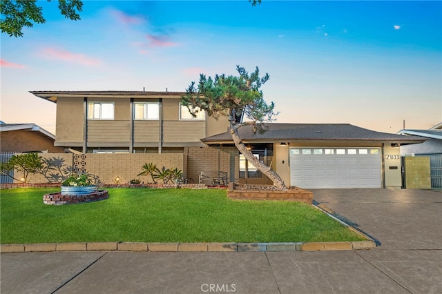 view of front of property with a garage and a lawn