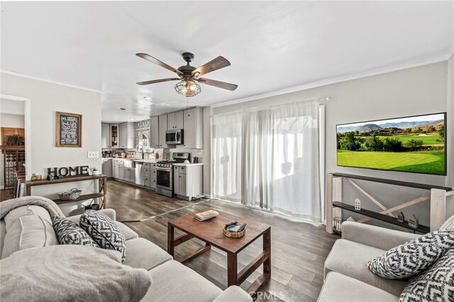 living room featuring crown molding, dark hardwood / wood-style floors, and ceiling fan