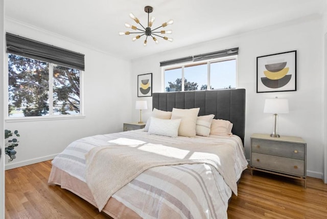 bedroom featuring wood-type flooring and an inviting chandelier