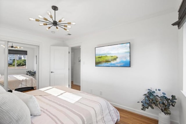 bedroom featuring an inviting chandelier and wood-type flooring