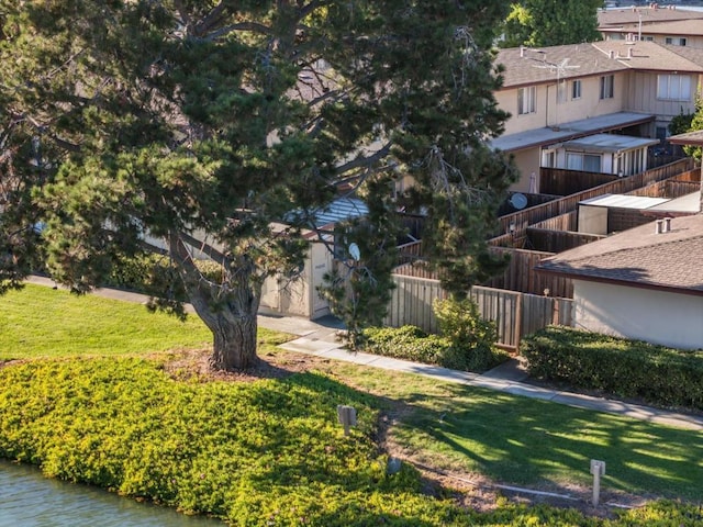 view of property's community with a water view and a lawn