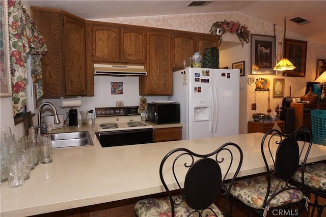 kitchen with white appliances, sink, kitchen peninsula, pendant lighting, and vaulted ceiling