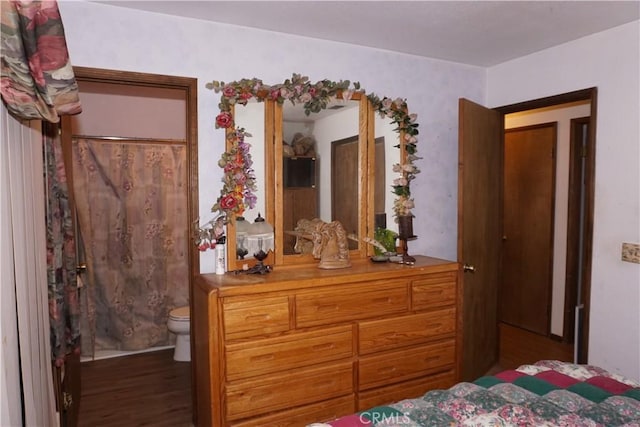 bedroom with dark hardwood / wood-style floors and ensuite bathroom